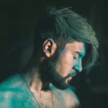 Cinematic close-up portrait of a man with closed eyes and beard, exuding a moody and artistic vibe.